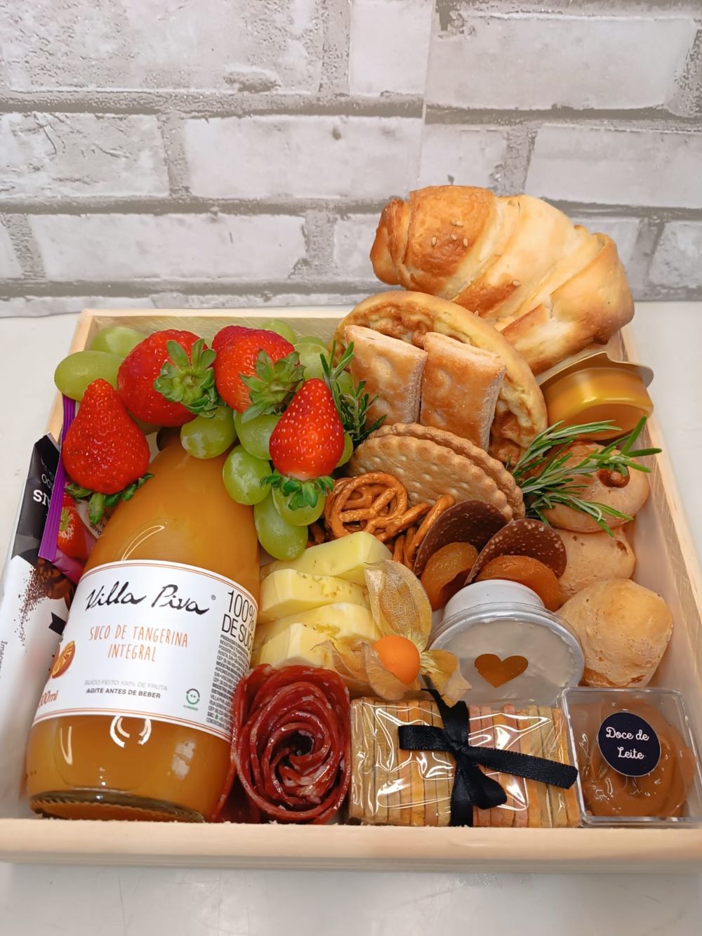Cesta de café da manhã com suco, frutas, pães e frios